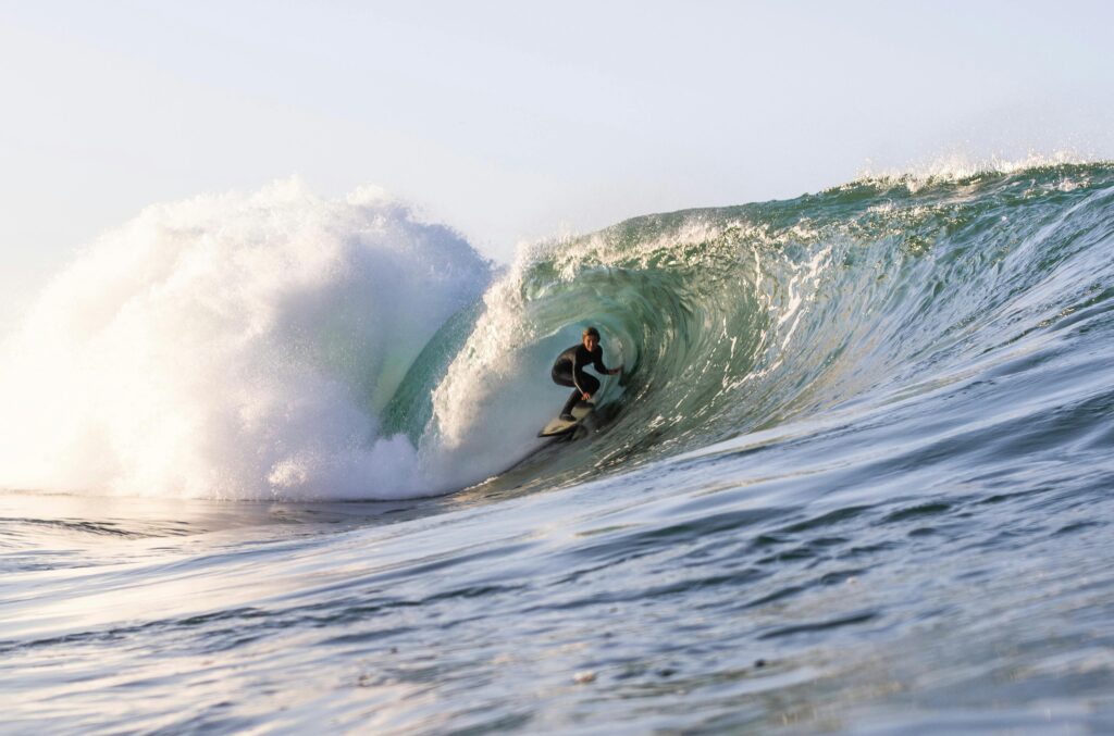 Surfer riding a massive wave in California, showcasing thrilling ocean action and skill.