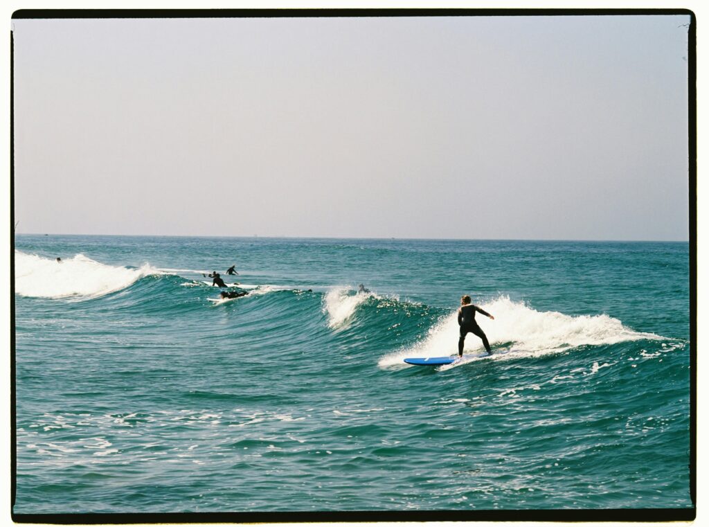 Surfers enjoying the waves on a sunny day at a Moroccan beach. Perfect for beach and adventure themes.